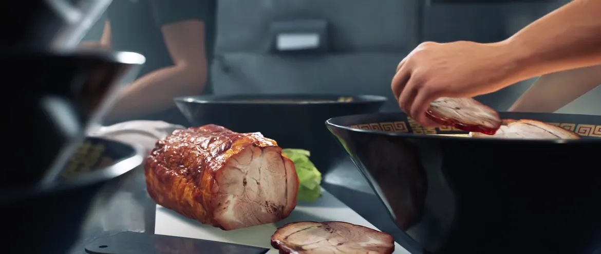 Japanese Ramen Simulator staff placing sliced chashu rosettes onto a noodle bowl in the official store gameplay clip