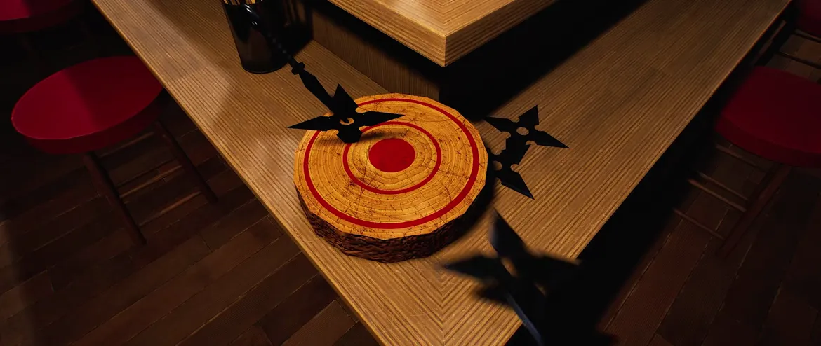Official Japanese Ramen Simulator gameplay clip frame: a black shuriken stuck in a round straw target on a wooden table, red counter stools behind and a second shuriken in the foreground