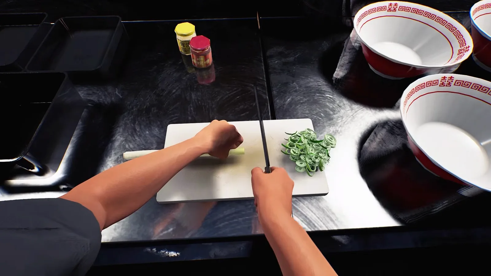 First-person view of hands slicing leek with a knife on a white cutting board in Japanese Ramen Simulator, with cut scallion rings, black ingredient pans and two empty ramen bowls on the prep counter